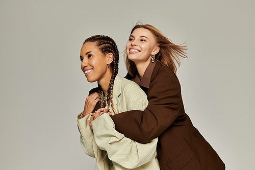 Two young women embrace warmly, radiating happiness on a crisp autumn day.