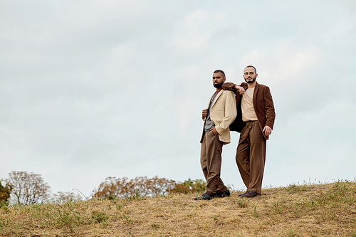 Handsome men showcase trendy autumn attire while enjoying a peaceful moment outdoors in nature.