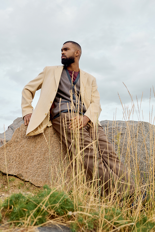 A handsome man poses confidently in autumn attire, basking in the serene beauty of nature's palette.