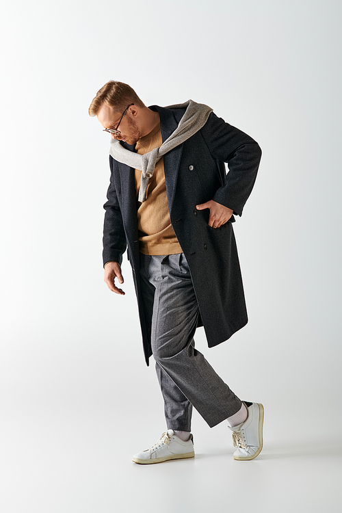 A stylishly dressed man confidently strides in a trench coat.