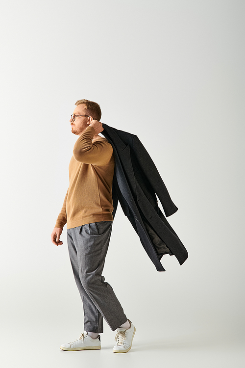 Stylish man walking on white backdrop.