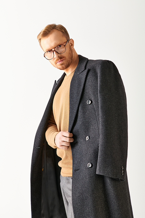 A stylish man in black coat and glasses strikes a dynamic pose.