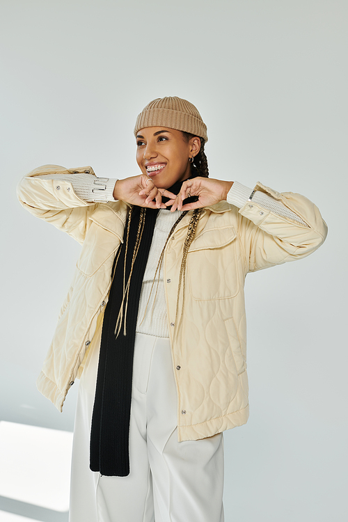 Happy african american woman in autumn stylish attire on white backdrop.