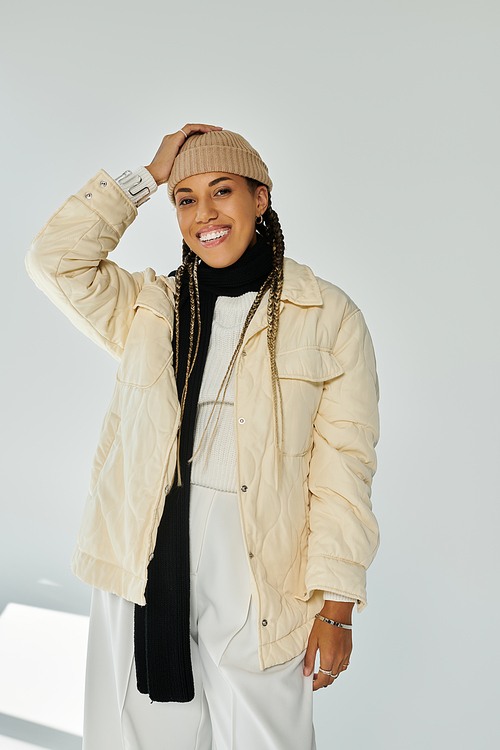 Delighted african american woman in autumn stylish attire on white backdrop.