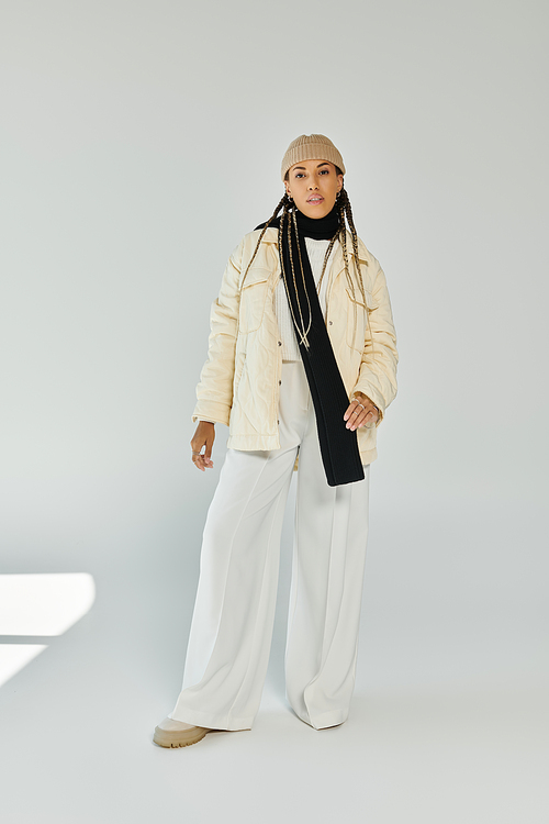 Trendy african american woman in autumn stylish attire on white backdrop.