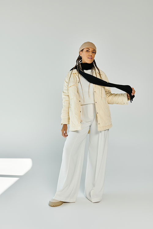 Fashionable african american woman in autumn stylish attire on white backdrop.