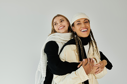 A young couple dressed in autumn layers shares a warm embrace, showcasing love and joy.