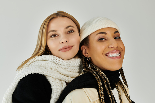 Two women share joyful moments in stylish autumn attire, radiating love and warmth.