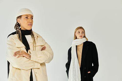 Two young women showcase their autumn outfits, radiating style and comfort in a warm atmosphere.