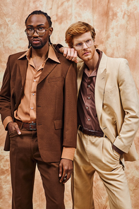 Two elegant, multicultural men in stylish suits standing side by side.