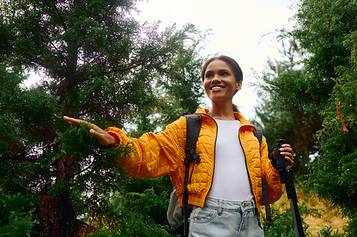 A spirited young woman enjoys a beautiful hike through colorful autumn foliage in a peaceful forest.