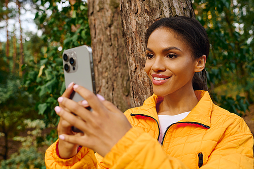 Joyful exploration unfolds as a young woman captures her adventurous spirit amidst vibrant autumn foliage.