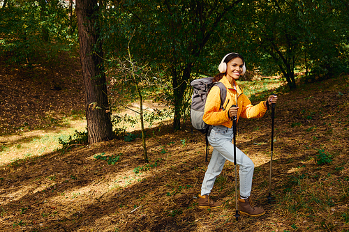 A young African American woman embarks on an adventurous hike amidst autumn foliage