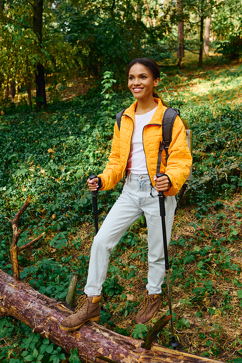 A young woman explores a scenic forest trail, embracing adventure during the colorful autumn season.