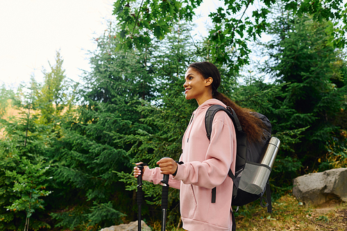 A young woman hikes through a colorful autumn forest, embracing the beauty of nature and adventure.