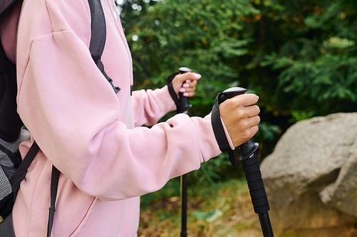 A young African American woman enjoys a hiking adventure in a vibrant autumn forest, surrounded by nature.