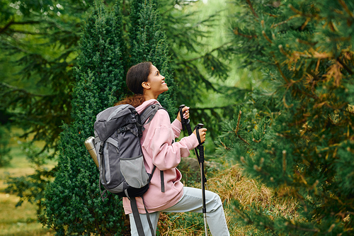 A young African American woman hikes through a colorful autumn forest, embracing the spirit of adventure.