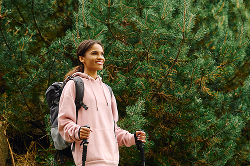 A young African American woman delights in her adventure as she hikes through a colorful autumn forest.