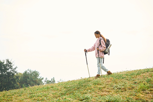 A spirited young woman explores the forest trails, immersed in autumn beauty while hiking.