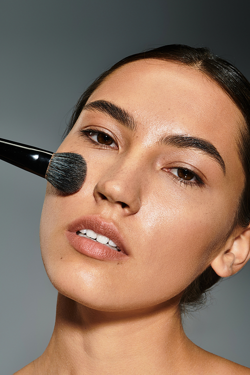 A makeup artist carefully applies foundation on a womans face to highlight her features.