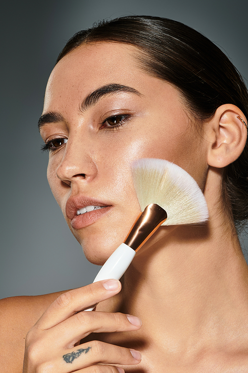 A young woman gently applies makeup, showcasing her natural beauty and glowing skin.