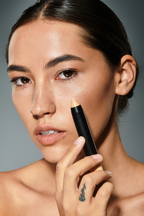 A woman showcases her makeup technique, highlighting her natural beauty and artistry.