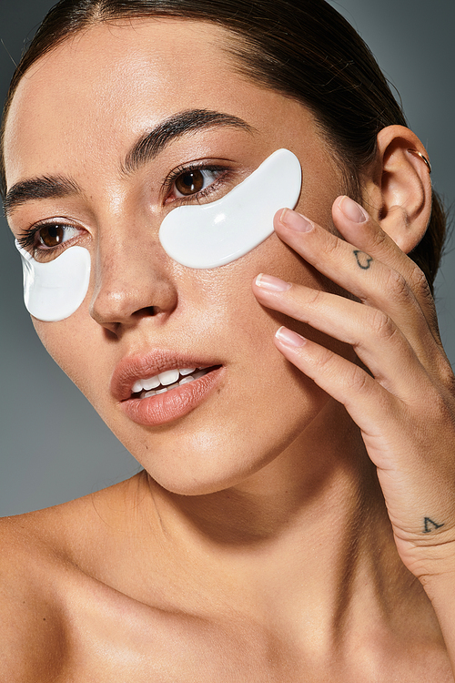 The woman applies soothing eye patches while enjoying a relaxing moment dedicated to self care.