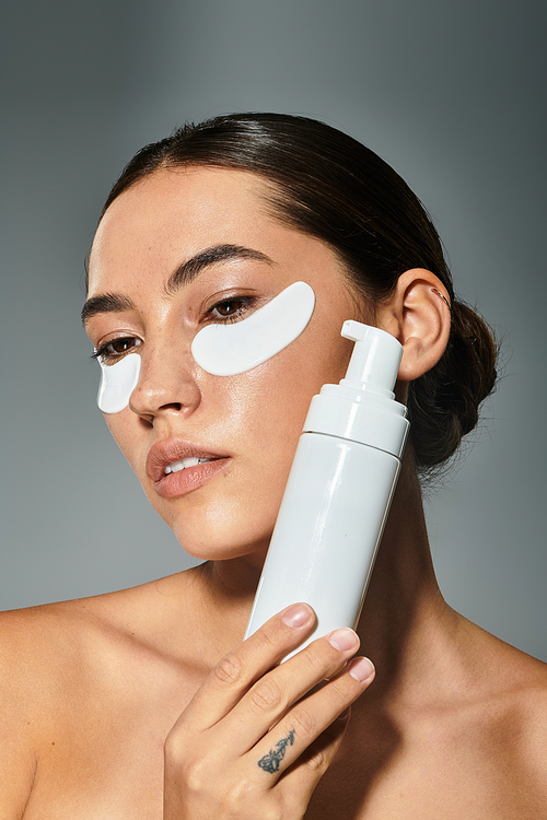 A woman engages in a relaxing skincare routine while holding a beauty product close to her face.