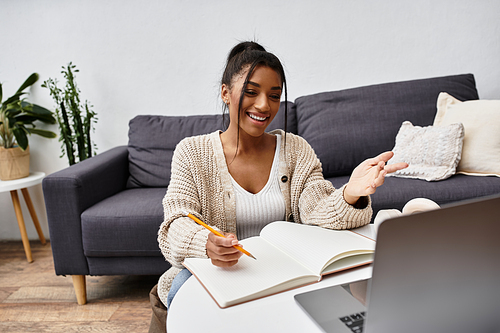 A youthful woman engages in remote studying from her comfortable home environment.