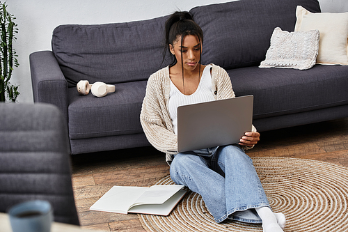 The young woman is engaged in her studies on a laptop, seated on a soft rug at home.