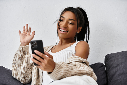 A cheerful young woman engages in remote learning at home, smiling as she studies.