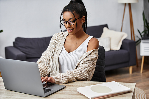 A beautiful young woman focuses on her remote studies in a stylish, inviting home environment.