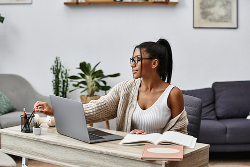 A young woman sits at her desk studying with enthusiasm amidst a serene home setting.