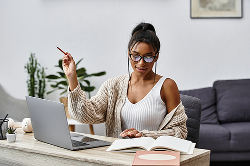 A beautiful young woman diligently studying at home, immersed in her learning environment.