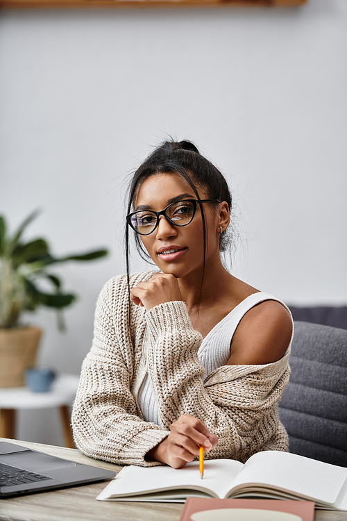 A young woman in comfortable clothing studies intently from her home, surrounded by greenery.