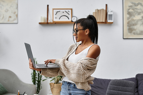 The woman engages with her laptop, enjoying a productive study session in her stylish home.