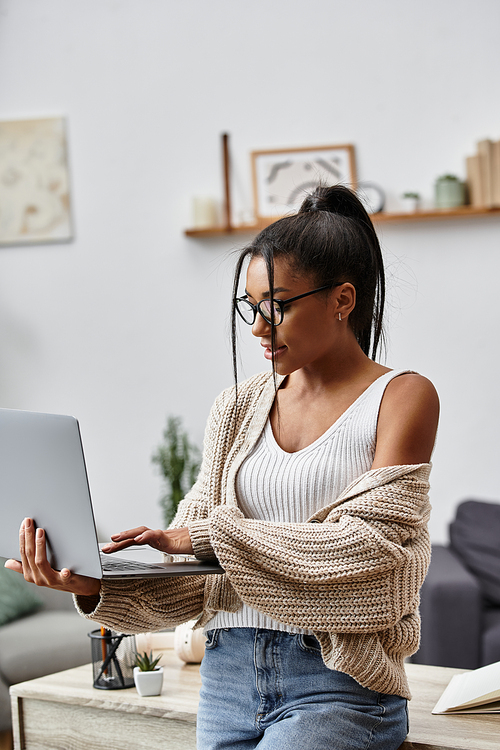 A young woman in a cozy environment studies remotely, focused on her laptop screen.