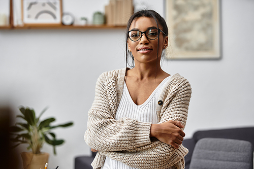 A young woman studies at home, cozy in her sweater, focused on her learning journey.