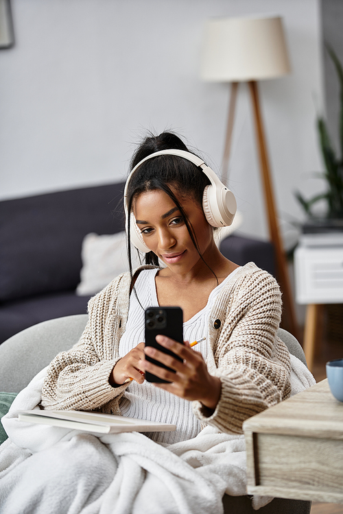 In a cozy living room, a young woman focuses on her studies, enjoying remote learning.