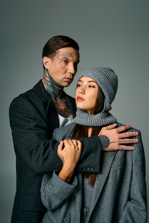 A young couple stands closely together, exuding a modern and fashionable vibe in winter attire.