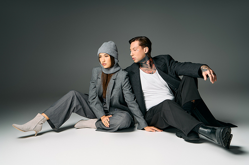 A young pair dressed in fashionable attire interacting in a chic studio environment