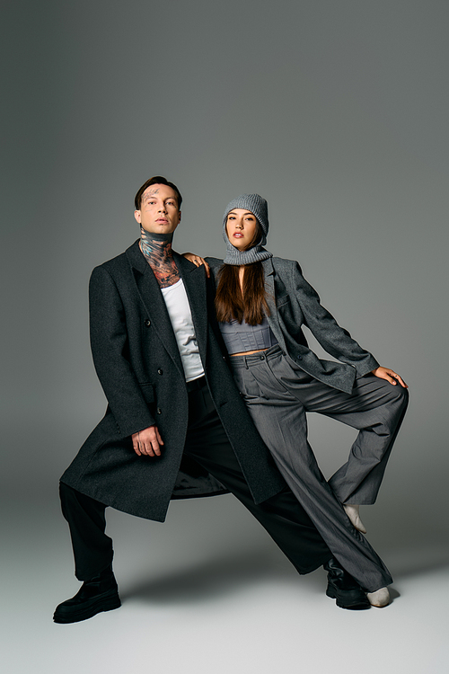 A young couple showcases modern fashion with confidence and creativity in a dynamic pose.