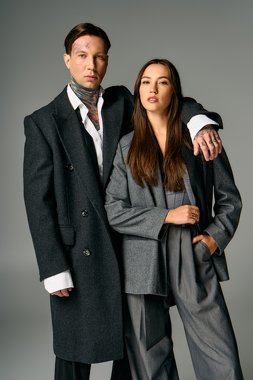 A young couple showcases their fashionable outfits with confidence and elegance in sleek attire.