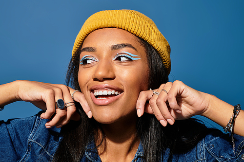 The young woman smiles radiantly, showcasing her stylish autumn wear and playful makeup.