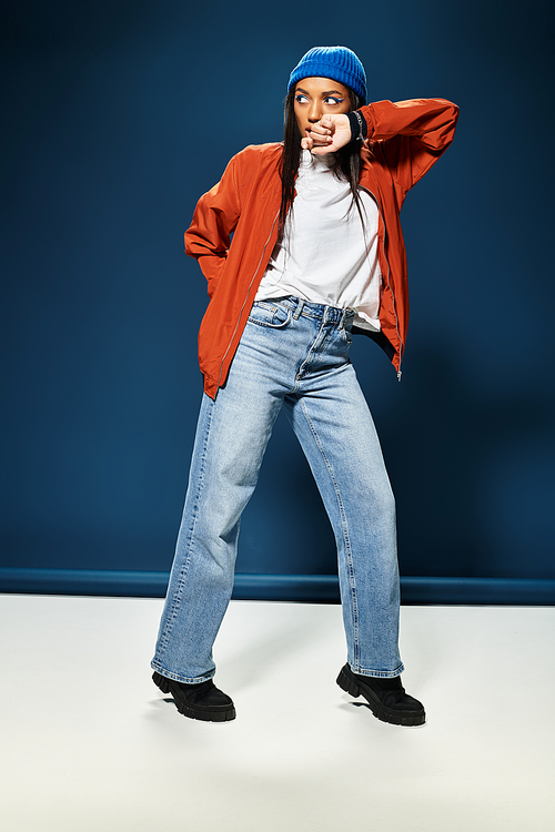 Dressed for autumn, a young woman exudes style and confidence while posing in a colorful setting.