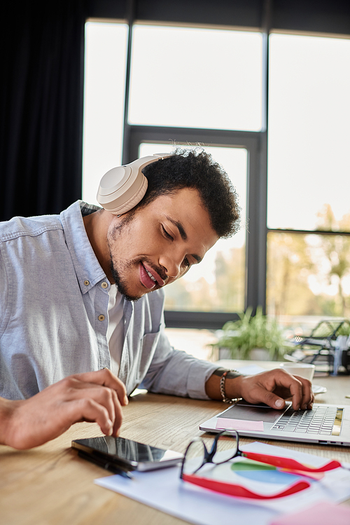 Focused individual enjoys melodies while multitasking in a stylish, bright work environment