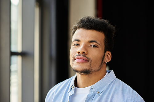 Handsome man smiles softly while enjoying the warm natural light in a stylish urban setting