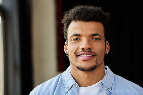 A charismatic man with a confident smile stands against a softly lit background, exuding charm.