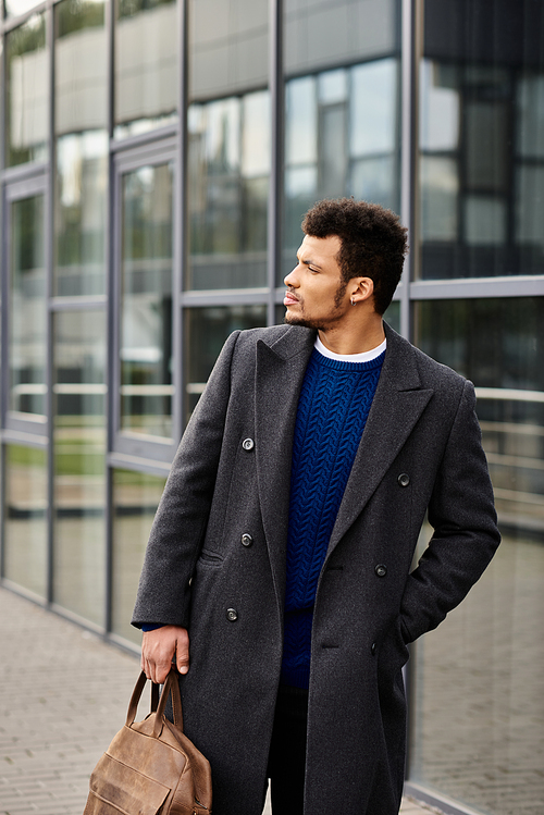 A well dressed man with a confident expression strolls by a contemporary glass building.