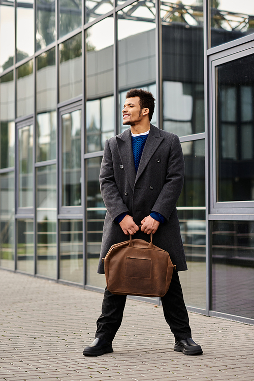 Dressed in a stylish coat, a man exudes confidence while holding a bag by a sleek structure.